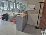 a room with a desk, chairs, and a lamp in it
