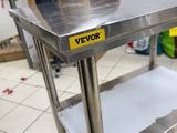 a stainless steel table with a yellow sign on it