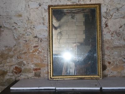 a mirror sitting on top of a table next to a wall