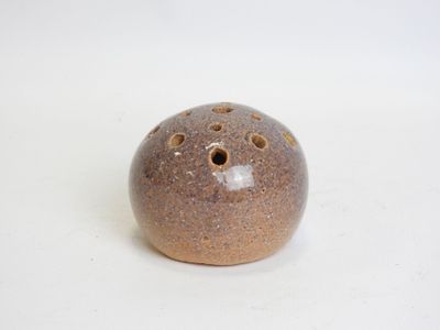 a brown ceramic ball with holes in it