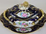 three blue and gold plates with flowers on them on a white surface