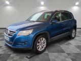 un SUV Volkswagen bleu garé dans un garage au sol carrelé