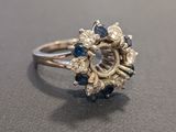 an image of a diamond and sapphire ring on a table