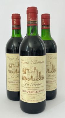 trois bouteilles de vin rouge posées sur une table blanche