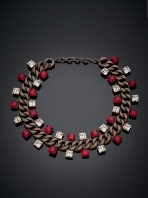 un collier composé de pierres rouges et blanches sur fond noir