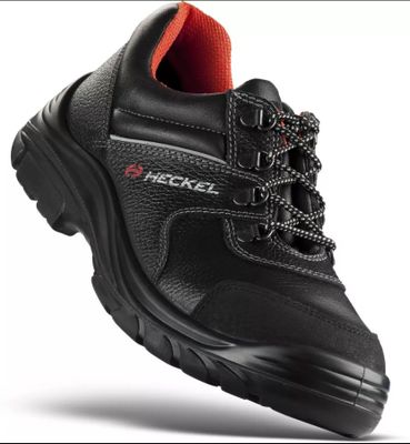 un gros plan sur une paire de chaussures de travail noires sur fond blanc