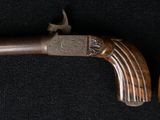 two old guns with wooden grips on a black background