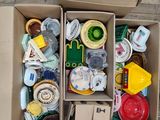 deux cartons remplis d'objets divers posés sur un plancher en bois