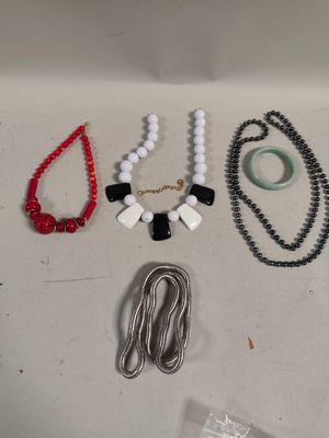 plusieurs colliers et bracelets disposés sur une surface blanche