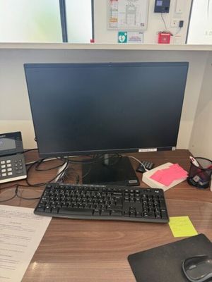a computer desk with a keyboard, mouse, and monitor