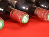 several bottles of wine are lined up on a red surface