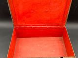 an open red suitcase sitting on top of a gray surface