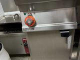 a machine that is sitting in a kitchen next to a trash can
