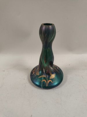 un vase bleu et vert posé sur une table blanche