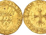 a gold coin with a cross and shield on it
