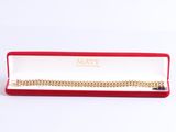 a red box with a gold chain bracelet inside of it