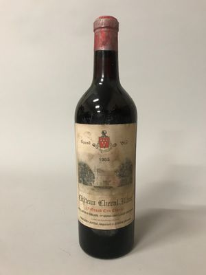 une vieille bouteille de vin posée sur une table blanche