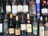 bottles of wine are lined up on a shelf in front of a wall