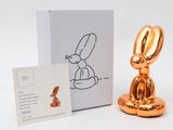 an image of a gold rabbit figurine next to a white box