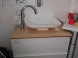a white sink sitting on top of a wooden counter