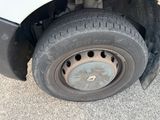 a white truck with a flat tire on the side of the road