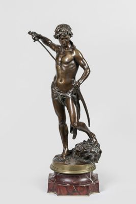 une statue en bronze représentant un homme avec un chien, posée sur un socle en marbre