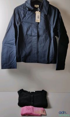 une veste bleue et un pantalon noir posés sur une table blanche