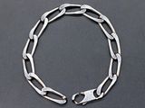 a close up of a silver chain bracelet on a black surface