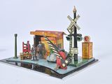 a small model of a train station with a red car in front of it