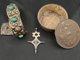 trois bijoux en argent et en turquoise posés sur un fond noir