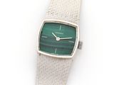 an image of a silver watch with a green face on a white background