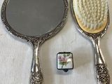 two mirrors and a brush sitting on a table