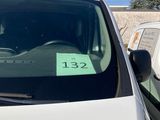 a white van with a green sticker on the windshield