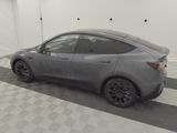 the tesla model y is parked in a clean garage