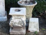 deux vases en ciment posés l'un à côté de l'autre par terre