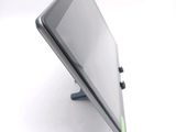 a tablet computer sitting on a stand on a white surface