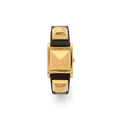 a close up of a gold and black watch on a white background