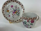 a close up of a cup and saucer on a white surface