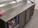 stainless steel counter top in a commercial kitchen with a refrigerator