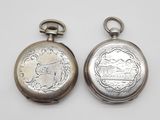 deux montres de poche en argent posées côte à côte sur une surface blanche
