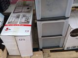 Plusieurs micro-ondes et autres appareils électroménagers sont empilés sur des palettes dans un magasin