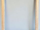 a wooden frame on a gray wall with a white background