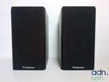 two black speakers sitting side by side on a white surface