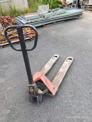 a pallet that is sitting on the ground in front of a pile of wood