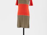 une robe à rayures orange et noires posée sur un présentoir pour mannequin