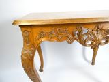 une table en bois dont le plateau est sculpté, sur fond blanc