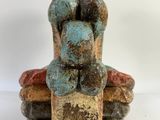 a close up of a sculpture of two people sitting on a rock