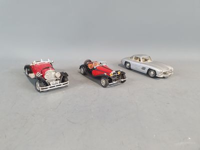 three toy cars sitting next to each other on a table