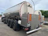 un grand camion-citerne argenté garé sur un parking
