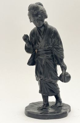 a black statue of a man holding a bag